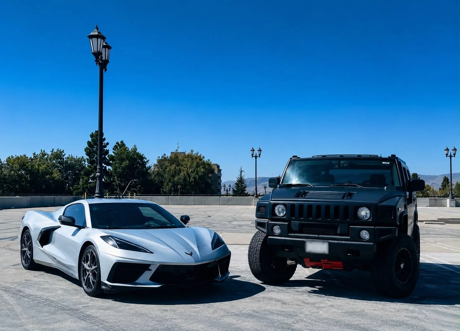Los dos premios de frente: el Corvette C8 blanco y el Hummer H2 negro, listos para el sorteo